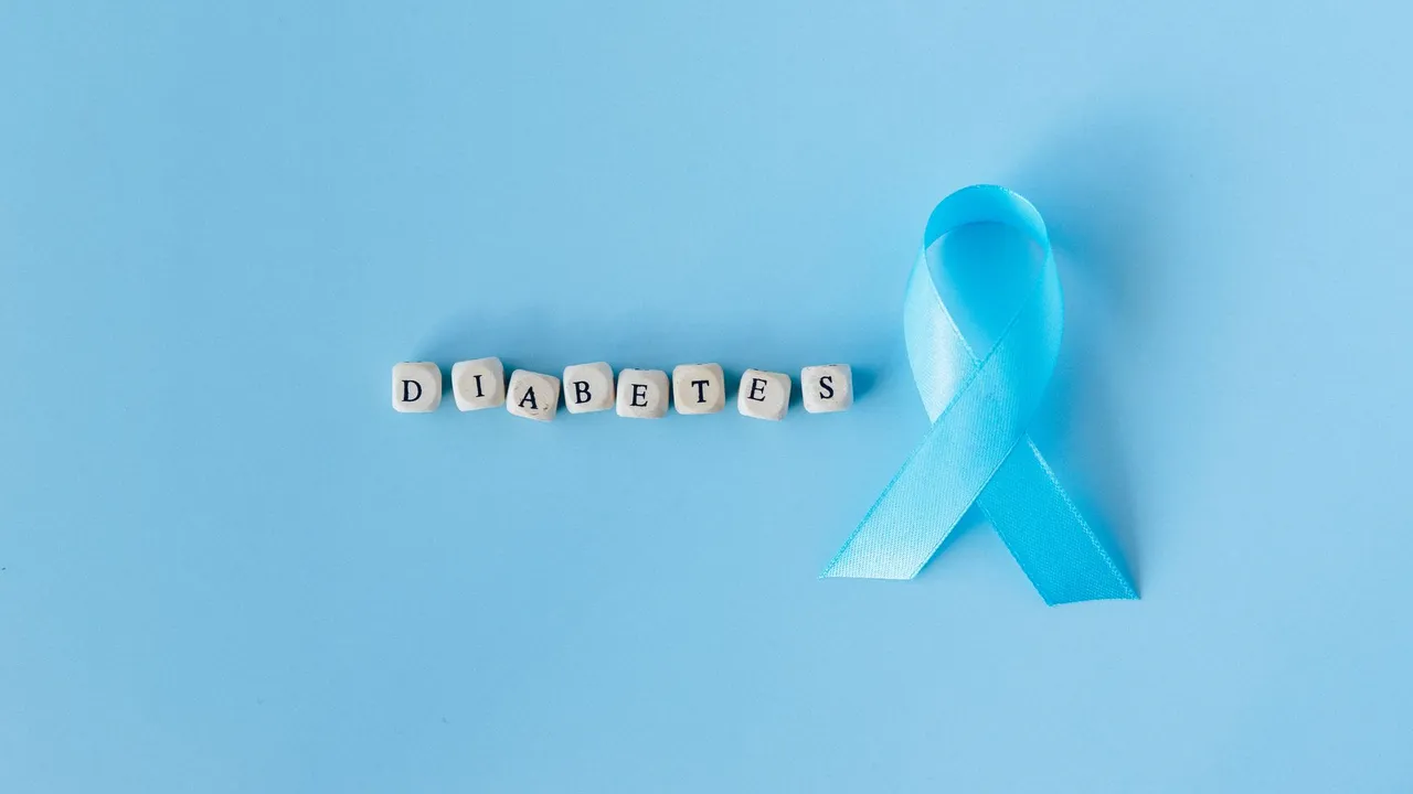 Blue ribbon signifies diabetes awareness on a light blue surface with letter dice spelling 'Diabetes'.