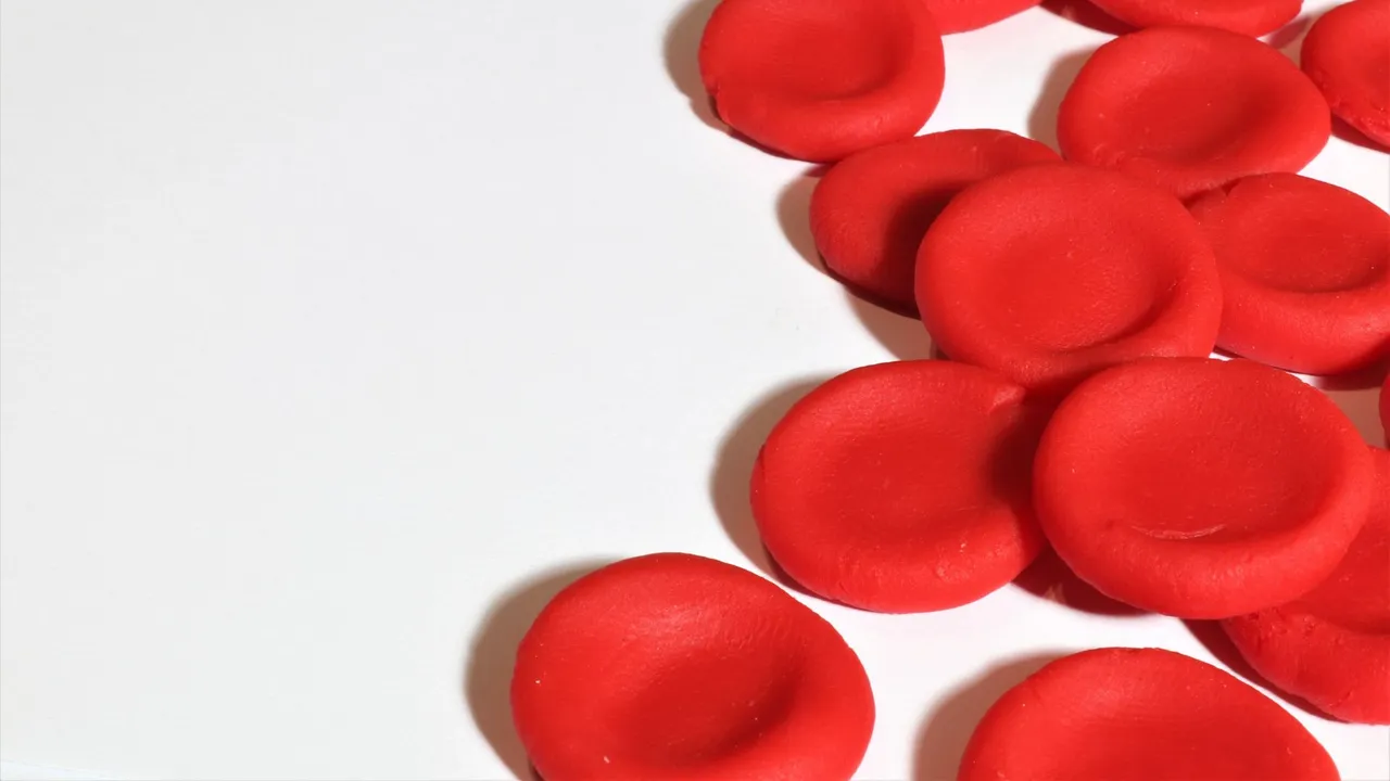 Artistic depiction of red blood cells on a white background, emphasizing medical concepts.