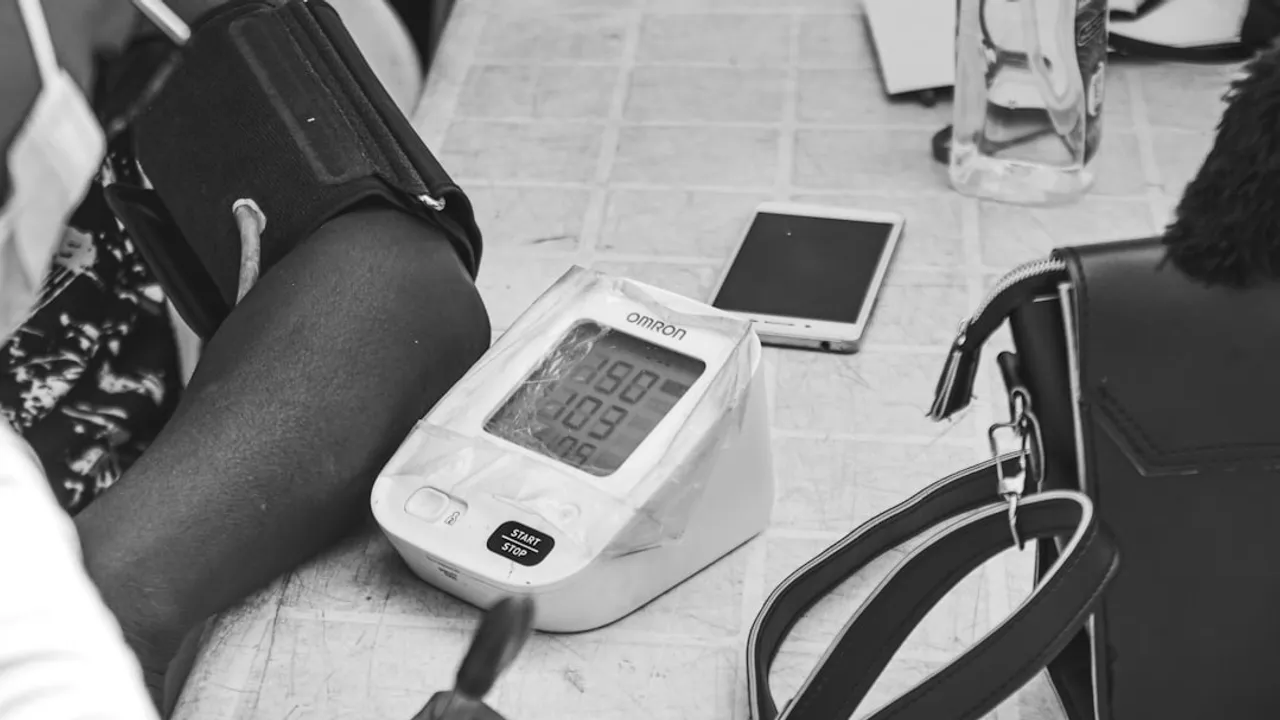 Digital blood pressure monitor checking a person's arm.